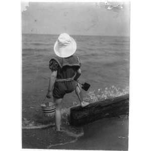  A summer child,rear view of child on beach,holding bucket 