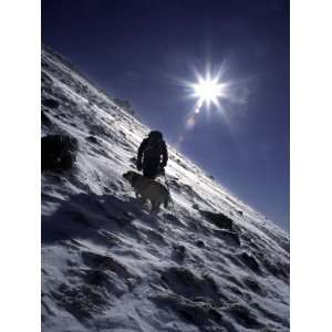 Man with Dog Climbing Arapahoe Peak in Strong Wind and Snow, Colorado 
