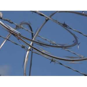  Close Up of a Barbed Wire Fence with Overlapping Metal 